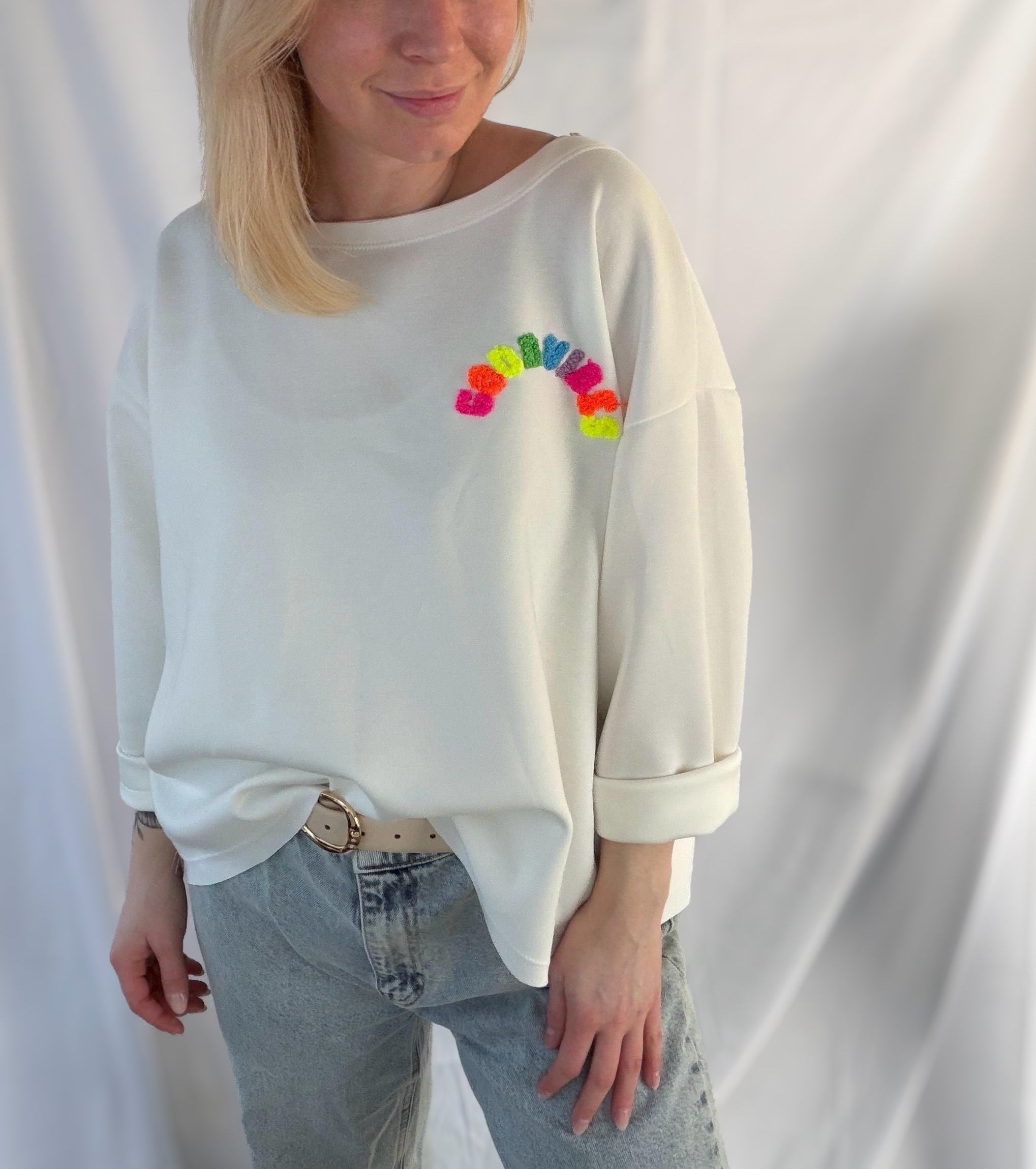 Weißer Good Vibes Pullover von Feinraummode, weiches Baumwollmaterial, bequemer Style, auf einem weißen Hintergrund fotografiert.