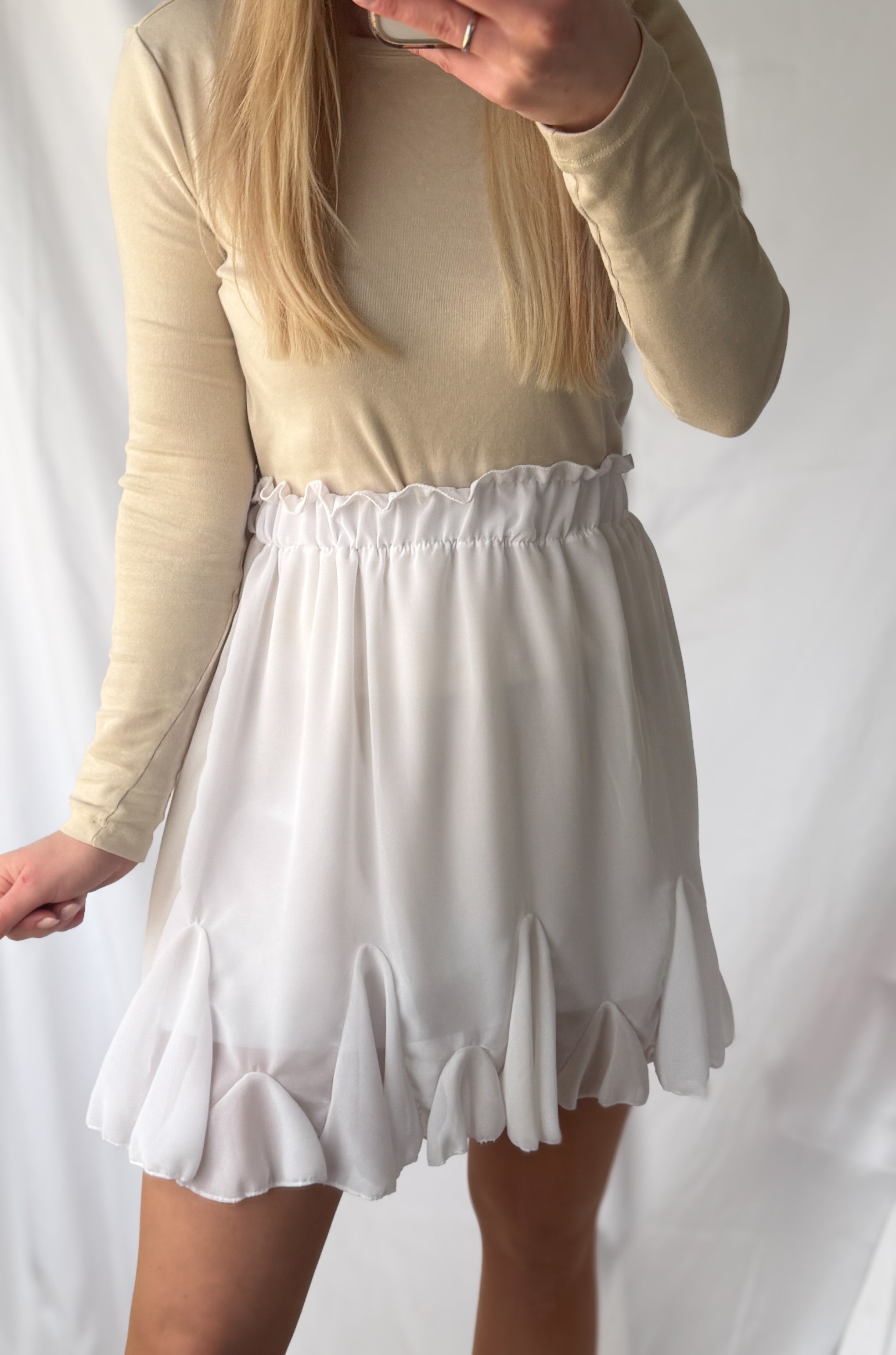 Weiße Volant-Rock von Feinraummode, elegante Mode mit fließendem Stoff und verspieltem Volant-Design, blickfangfähiges Kleidungsstück