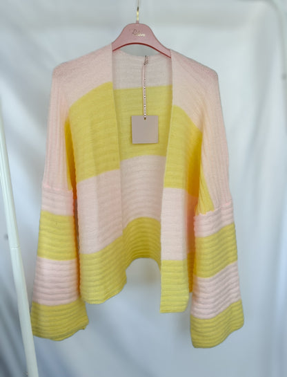 Der Gestreifter Cardigan Luna - gelb rosa von Feinraummode hängt auf einem rosafarbenen Bügel vor weißem Hintergrund und zeigt sich mit seinen weichen, langen Ärmeln und den breiten pastellrosa und gelben Streifen - perfekt für Ihre Frühlingsgarderobe.