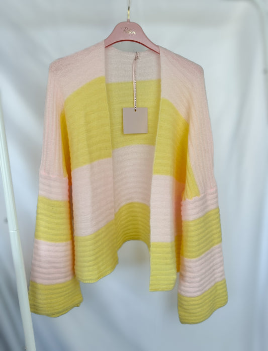 Der Gestreifter Cardigan Luna - gelb rosa von Feinraummode hängt auf einem rosafarbenen Bügel vor weißem Hintergrund und zeigt sich mit seinen weichen, langen Ärmeln und den breiten pastellrosa und gelben Streifen - perfekt für Ihre Frühlingsgarderobe.