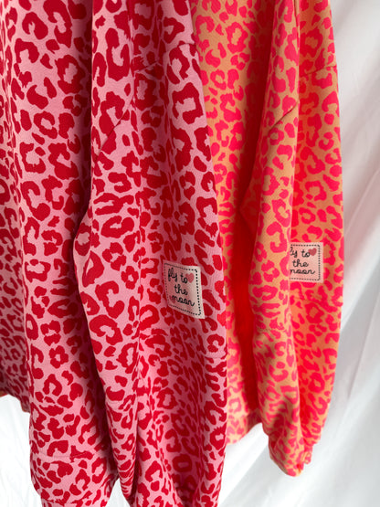 Weißes Oversize Sweatshirt im Leoparden-Look von Feinraummode, orangefarbene Muster, bequemes Casual-Design, modischer Animal-Print.