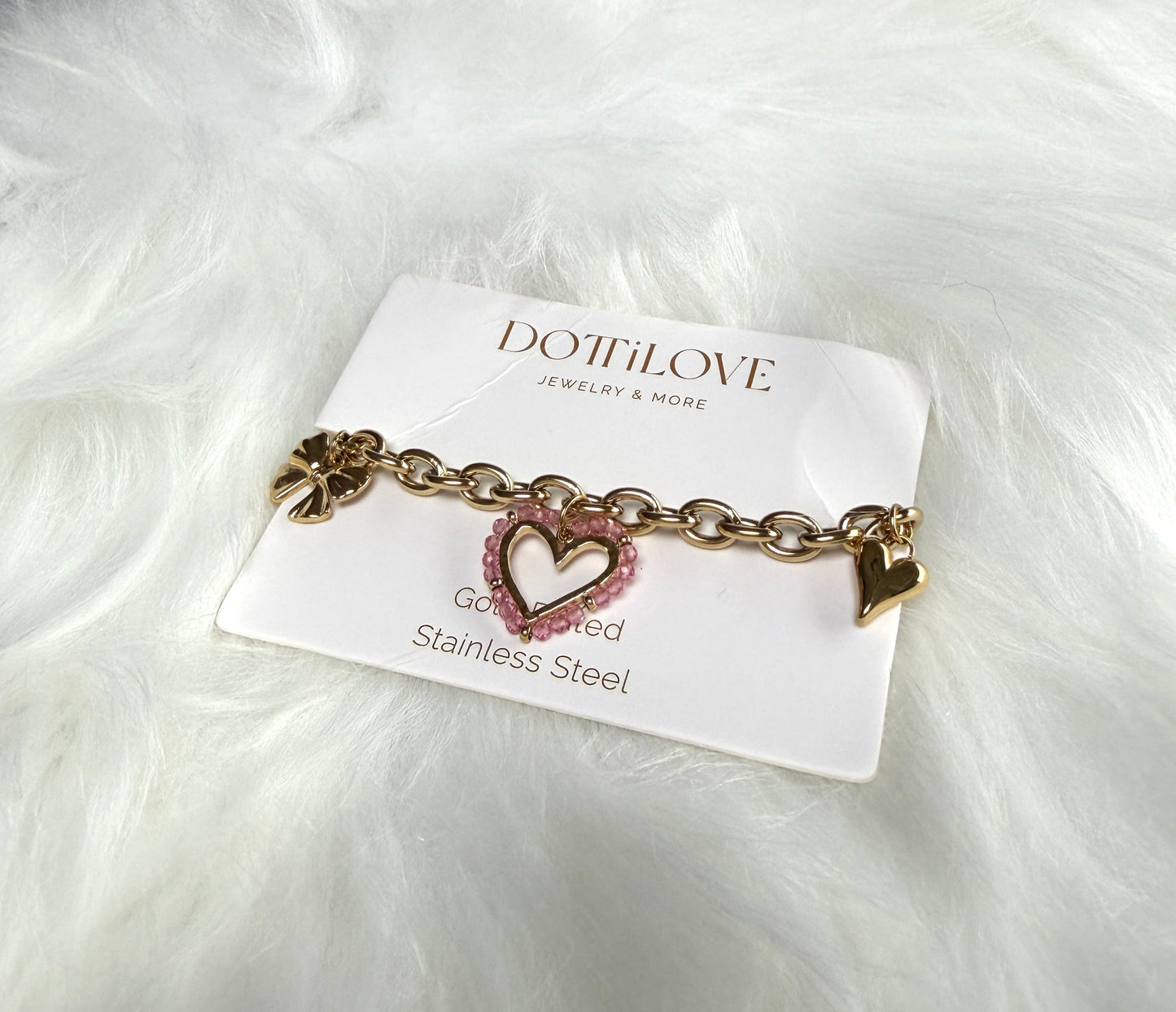 Edelstahl Armband mit Herz- und Charm-Anhängern in Gold, elegantes Schmuckstück von Feinraummode, detailreiche verzierte Oberfläche.