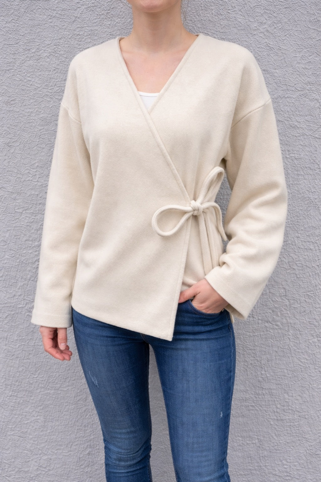 Feinraummode Binden-Pullover Mira in weichem Stoff, mit modischem Design und lockerer Passform, auf einem Model getragen.